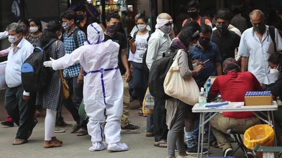 So far, 23,170,964 samples have been tested for the coronavirus disease in Karnataka. In picture - Health worker directs arriving passengers towards Covid-19 testing counter outside a train station in Bengaluru. (AP) So far, 23,170,964 samples have been tested for the coronavirus disease in Karnataka. In picture - Health worker directs arriving passengers towards Covid-19 testing counter outside a train station in Bengaluru. (AP)