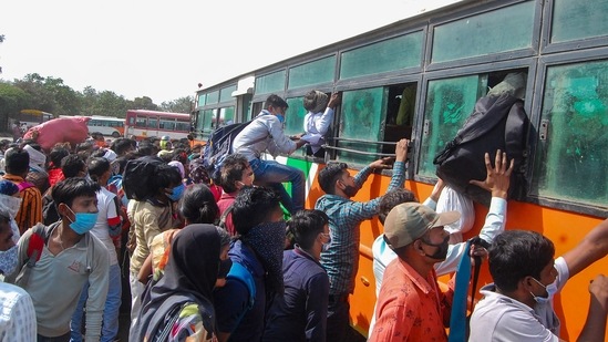 Migrants board buses for their native places amid surge in Covid-19 cases, at Jhakakati Bus Stand in Kanpur on Wednesday. (PTI Photo )