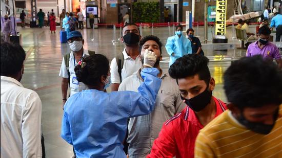 A health worker collects swab samples from travellers at Chhatrapati Shivaji Maharaj Terminus (CSMT). (Bhushan Koyande/ HT Photo) A health worker collects swab samples from travellers at Chhatrapati Shivaji Maharaj Terminus (CSMT). (Bhushan Koyande/ HT Photo)