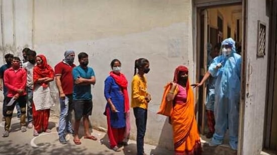 A Health worker asks people to maintain the queue as they wait to give their swab samples to test for COVID-19 in New Delhi, India, Friday, April 16, 2021. India recorded another high of 217,353 new cases in the past 24 hours, pushing its total since the pandemic began past 14.2 million. The Health Ministry also reported 1,185 fatalities in the past 24 hours, raising deaths to 174,308. (AP Photo/Manish Swarup) (AP) A Health worker asks people to maintain the queue as they wait to give their swab samples to test for COVID-19 in New Delhi, India, Friday, April 16, 2021. India recorded another high of 217,353 new cases in the past 24 hours, pushing its total since the pandemic began past 14.2 million. The Health Ministry also reported 1,185 fatalities in the past 24 hours, raising deaths to 174,308. (AP Photo/Manish Swarup) (AP)