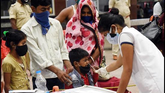A health worker takes swab samples of a migrant family arriving from Maharashtra outside a Covid-19 testing counter, amid the rise in viral cases across the country, at Patna railway station in Patna on Friday. (ANI PHOTO.) A health worker takes swab samples of a migrant family arriving from Maharashtra outside a Covid-19 testing counter, amid the rise in viral cases across the country, at Patna railway station in Patna on Friday. (ANI PHOTO.)