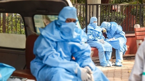 Family members wearing PPE kits, wait during the cremation of a Covid-19 victim at the Nigambodh Ghat in New Delhi on Friday. (PTI PHOTO.) Family members wearing PPE kits, wait during the cremation of a Covid-19 victim at the Nigambodh Ghat in New Delhi on Friday. (PTI PHOTO.)