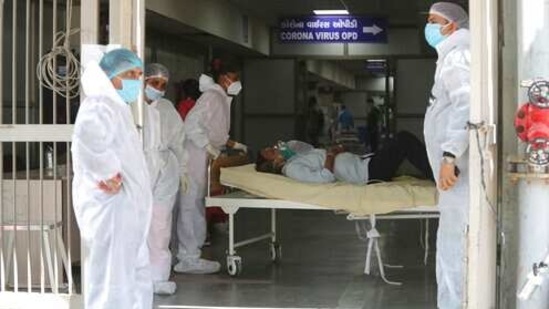 Health workers carry a patient into a dedicated Covid-19 hospital in Ahmedabad, The picture is still grim in parts of Europe and Asia as variants of the virus fuel an increase in new cases and the worldwide death toll closes in on 3 million.(AP)