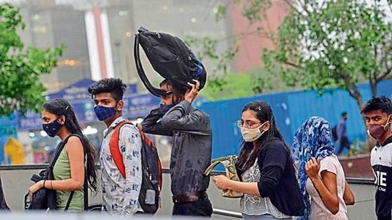 Commuters stand outside the Rajiv Chowk Metro Station during rain on Friday. (PTI) Commuters stand outside the Rajiv Chowk Metro Station during rain on Friday. (PTI)