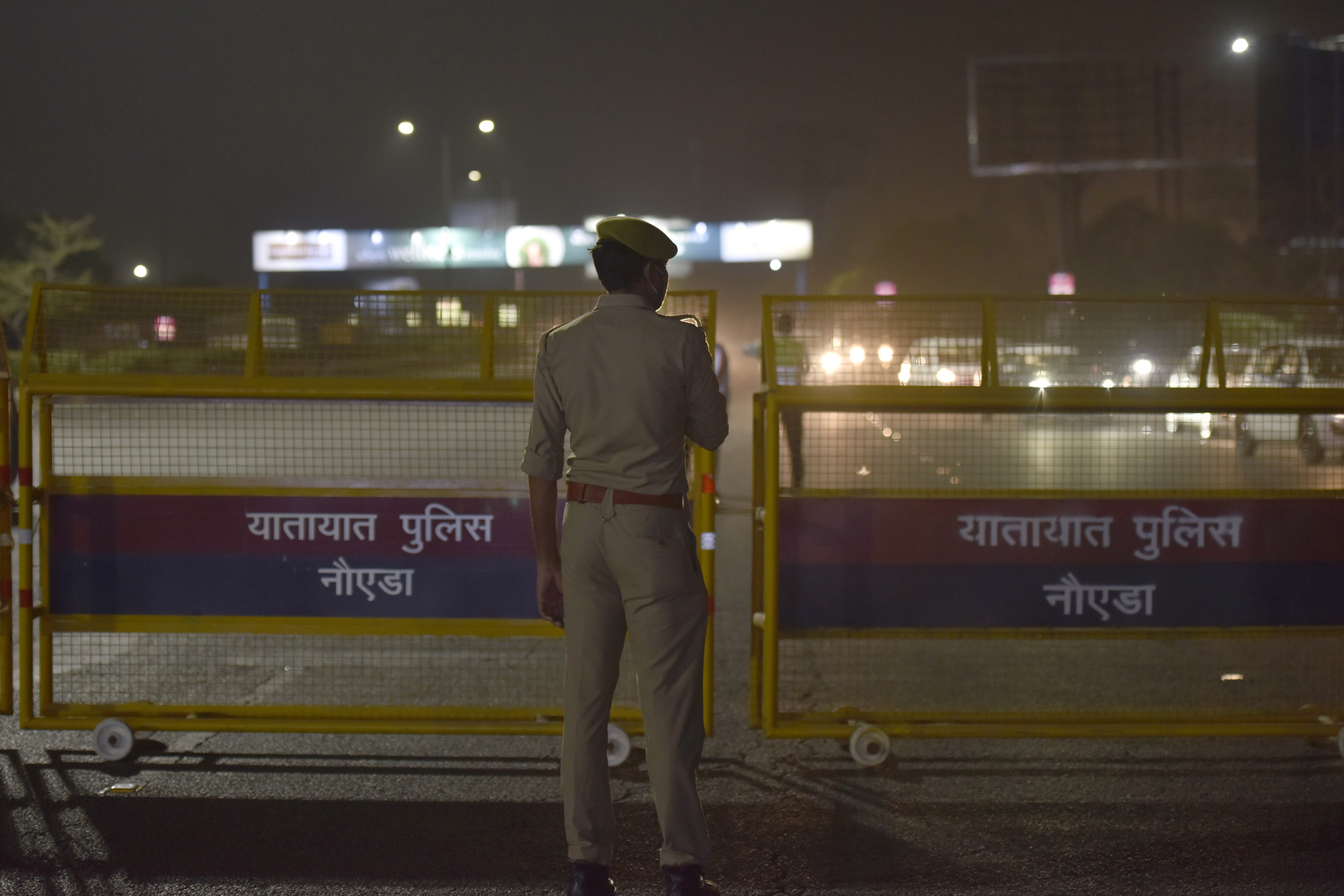 Police personnel drawing out barricading at DND Flyway to check commuters entering Noida from Delhi after an 8pm night curfew, in Noida. (Photo by Sunil Ghosh / Hindustan Times) Police personnel drawing out barricading at DND Flyway to check commuters entering Noida from Delhi after an 8pm night curfew, in Noida. (Photo by Sunil Ghosh / Hindustan Times)