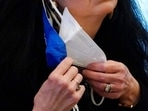 FILE - In this Thursday, Feb. 4, 2021 file photo, a state legislator adjusts her face masks while asking a question at the Capitol in Jackson, Miss. A government study released on Wednesday, Feb. 10, 2021, finds that wearing two masks can better than one, in protecting against coronavirus infection. But health officials are stopping short of recommending that everyone double-up. “The first challenge is to get as many as people as possible masking. And then for those that do mask, to help them get the best benefit out of that mask,