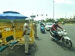 Police personnel screen commuters at the Delhi-Noida entry gate in Sector 14A during a weekend curfew imposed by the government of Delhi. (Photo by Sunil Ghosh / Hindustan Times)