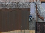 A Haitian migrant climbs the Mexico-US border fence near the El Paso border crossing, in Ciudad Juarez, Chihuahua state, Mexico. 
