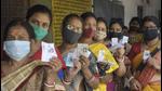 Women show their voter ID cards as they stand in a queue to cast their vote at a polling station during the 5th phase of West Bengal assembly polls, amid a surge in Covid-19 cases across the country at Ranaghat in Nadia on Saturday. (PTI PHOTO.)