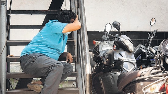 A distraught relative of a Covid-19 patient sits on the steps near the parking lot of Naidu hospital in Pune. Relatives of patients have been running from pillar to post searching for injections, oxygen. (Pratham Gokhale/HT Photo)