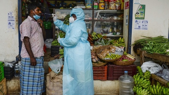 A health worker taking a swab sample from a shopkeeper for a RT-PCR Covid-19 test in Chennai.(Arun Sankar / AFP)
