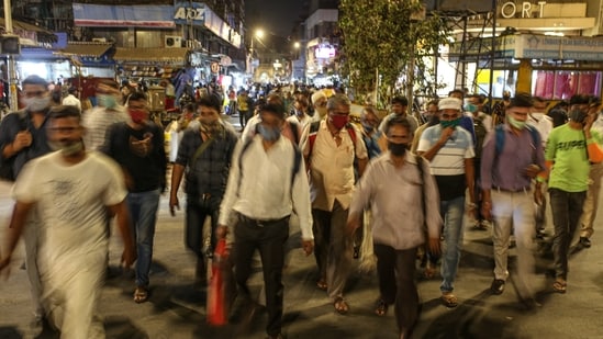 Pedestrians wearing protective masks walk through Crawford Market at night in Mumbai, India, on Wednesday, March 31, 2021.(Bloomberg)