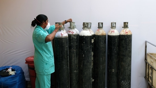 A health worker check oxygen cylinders at a makeshift Covid-19 quarantine facility set up in a banquet hall in New Delhi, India, on Tuesday, April 13, 2021. (Bloomberg) A health worker check oxygen cylinders at a makeshift Covid-19 quarantine facility set up in a banquet hall in New Delhi, India, on Tuesday, April 13, 2021. (Bloomberg)