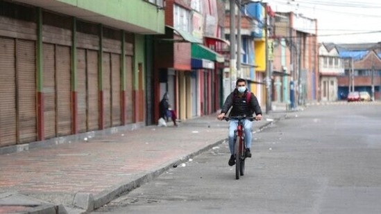 A rides past shuttered businesses during a strict lockdown to help curb the spread of the new coronavirus, in Bogota, Colombia.(AP) A rides past shuttered businesses during a strict lockdown to help curb the spread of the new coronavirus, in Bogota, Colombia.(AP)