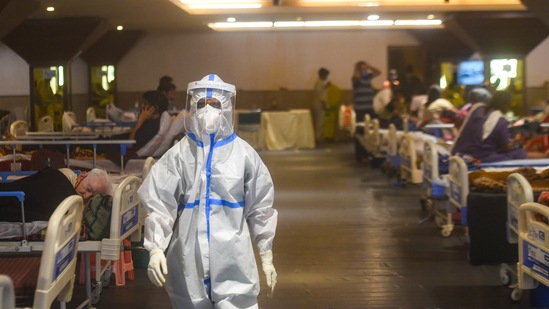 A health worker in PPE on the rounds in a Covid-19 ward at the temporary Covid Care facility at Shehnai Banquet in New Delhi. The fourth wave of the infection that has stormed the Capital over the past few weeks has been the most devastating so far, with infections and deaths soaring to levels not seen at any stage since the outbreak of the pandemic.(Amal KS / HT Photo)