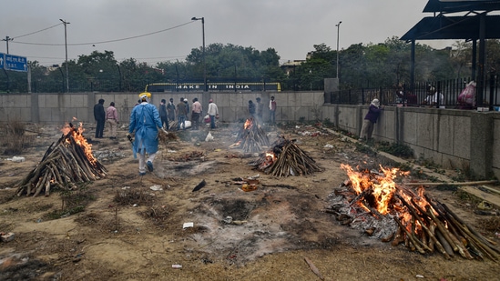People who died of Covid-19 being cremated at a field near the Seemapuri Cremation Grounds in New Delhi on April 16. “The workers come at 5am and start putting the wood on the pyre so that people don’t have to wait. From two to three bodies, we are now cremating around 35 bodies per day. Earlier, we would take time but now, we have to ensure that the cremation is wrapped in less than 30 minutes so that there is no backlog. The number of bodies arriving here for cremation is more than what we saw in November,” said Sharma.(Manvender Vashisht / PTI)