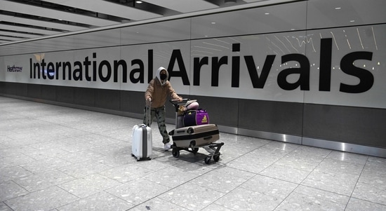 A passenger wearing a face mask as a precautionary measure against COVID-19, walks through the arrivals hall after landing at London Heathrow Airport in west London. (AFP) A passenger wearing a face mask as a precautionary measure against COVID-19, walks through the arrivals hall after landing at London Heathrow Airport in west London. (AFP)