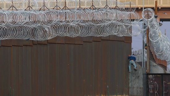 A Haitian migrant climbs the Mexico-US border fence near the El Paso border crossing, in Ciudad Juarez, Chihuahua state, Mexico. (AFP) A Haitian migrant climbs the Mexico-US border fence near the El Paso border crossing, in Ciudad Juarez, Chihuahua state, Mexico. (AFP)