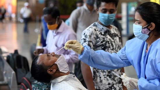 A health worker collects swab samples from a passenger at the Chhatrapati Shivaji Maharaj Terminus on Friday.(PTI) A health worker collects swab samples from a passenger at the Chhatrapati Shivaji Maharaj Terminus on Friday.(PTI)