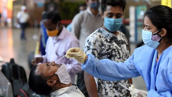 A health worker takes swab samples from a passenger at Chhatrapati Shivaji Maharaj Terminus Railway Station, amid spike in Covid-19 cases in Mumbai, Friday. (PTI Photo ) A health worker takes swab samples from a passenger at Chhatrapati Shivaji Maharaj Terminus Railway Station, amid spike in Covid-19 cases in Mumbai, Friday. (PTI Photo )