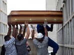 The remains of a woman who died from complications related to Covid-19 are placed into a niche by cemetery workers and relatives at the Inahuma cemetery in Rio de Janeiro, Brazil on April 13. The global death toll from the coronavirus topped a staggering 3 million people on April 17 amid repeated setbacks in the worldwide vaccination campaign and a deepening crisis in places such as Brazil, India and France.(Silvia Izquierdo / AP)