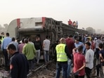 People gather at the site where train carriages derailed in Qalioubia province, north of Cairo, Egypt.