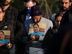 Family members hold a photo of their loved one during a candlelight vigil in Krannert Park in Indianapolis, Indiana on April 17, 2021, 