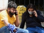 Family members on their phones as they react to the death of a relative outside Lok Nayak hospital on Sunday afternoon.(PTI) Family members on their phones as they react to the death of a relative outside Lok Nayak hospital on Sunday afternoon.(PTI)