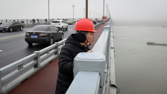 Volunteer Chen Si looks out at the Yangtze river from the Nanjing bridge in Jiangsu province, China on April 2. Chen has patrolled the 3.2 km long Nanjing bridge soaring above China's Yangtze river in Nanjing for some 18 years, determined to stop the desperate from jumping into the swirling waters below.(Wang Zhao / AFP)