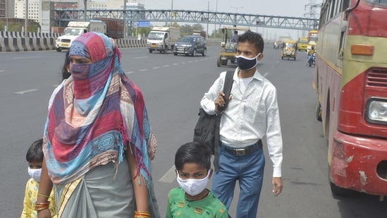 Migrant workers wait for buses at Delhi Meerut Expressway, near Indirapuram, in Ghaziabad. (Sakib Ali /Hindustan Times)