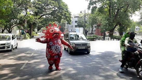 A man wearing a Covid-19 costume performs on the road to create awareness about the Covid-19 vaccination in Pune on Sunday. (ANI Photo) A man wearing a Covid-19 costume performs on the road to create awareness about the Covid-19 vaccination in Pune on Sunday. (ANI Photo)