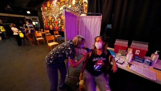 Allison Richter receives the Moderna COVID-19 vaccine from volunteer RN Maggie Baker, during a vaccine event hosted by Nola Ready, where people received a free drink at the bar if they received a COVID-19 vaccine, at The Howling Wolf, a music venue and bar, in New Orleans, Tuesday, April 13, 2021. Louisiana is making a full-court press to get shots in arms, with sometimes creative outreach to make it as easy as possible to get vaccinated. (AP Photo/Gerald Herbert)(AP)