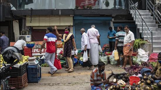 People wearing masks as a precaution against the coronavirus while buying vegetables at a Sunday market in Kochi, Kerala. (AP PHOTO.)