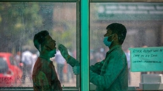 A health worker takes a swab sample to test for Covid-19 at a government hospital in Noida. (AP) A health worker takes a swab sample to test for Covid-19 at a government hospital in Noida. (AP)
