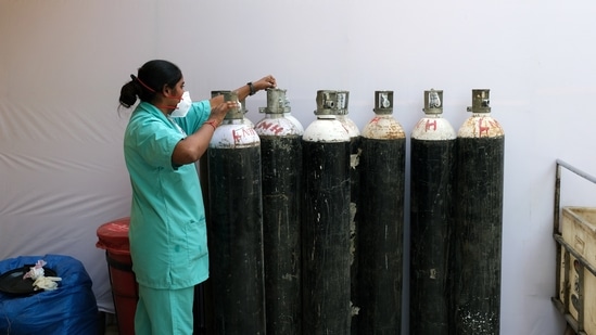 A health worker checks oxygen cylinders at a makeshift Covid-19 quarantine facility set up in a banquet hall in New Delhi, India. (Bloomberg)