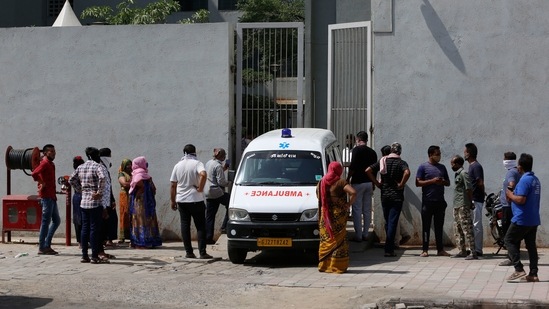Relatives of a patient who died of Covid-19, wait to collect the dead body outside a dedicated government hospital in Ahmedabad on April 17. Worldwide, deaths are on the rise again, running at around 12,000 per day on average, and new cases are climbing too, eclipsing 700,000 a day. (Ajit Solanki / AP)