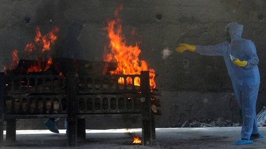 A municipal worker in personal protective suit performs last rites during the cremation of a Covid-19 victim in Vasai, outskirts of Mumbai on April 15. The WHO chief noted that several countries in Asia and the Middle East have seen large increases in cases. This is despite the fact that more than 780 million doses of vaccine have now been administered globally, he said according to ANI. (Rafiq Maqbool / AP)