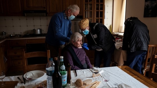 A medical worker (R) vaccinates a woman above the age of eighty with a dose of the Covid-19 Moderna vaccine on April 17 in Ussolo, Italy. Globally, about 87% of the 700 million doses dispensed have been given out in rich countries. While 1 in 4 people in wealthy nations have received a vaccine, in poor countries the figure is 1 in more than 500, AP reported. (Marco Bertorello / AFP)