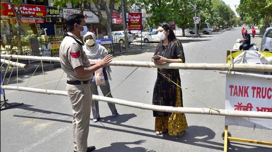 Police stopping a woman from going out of the containment zone in Ludhiana on Monday. (Gurpreet Singh/HT) Police stopping a woman from going out of the containment zone in Ludhiana on Monday. (Gurpreet Singh/HT)