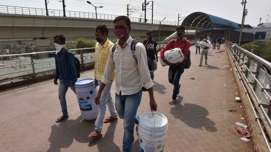 Migrant workers are seen at Anand Vihar Bus Terminal (ISBT) as they head to their native place amid fears of a total lockdown due to the surge in COVID-19 cases, in New Delhi, India, on Sunday, April 18, 2021. (Sanjeev Verma/HT PHOTO)
