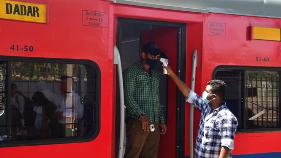 A health worker screens a passenger at a Dadar railway station during restrictions imposed by the Maharashtra government amidst rising Covid-19 cases. (Bhushan Koyande/HT Photo) A health worker screens a passenger at a Dadar railway station during restrictions imposed by the Maharashtra government amidst rising Covid-19 cases. (Bhushan Koyande/HT Photo)