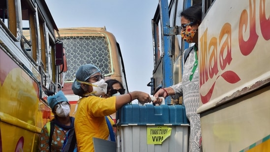 Polling officials carrying Electronic Voting Machines (EVMS) and other materials from a distribution centre in Nadia. (PTI Photo)