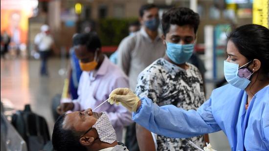 A health worker takes swab samples from a passenger at Chhatrapati Shivaji Maharaj Terminus Railway Station, amid spike in Covid-19 cases, in Mumbai on Friday, April 16. (File photo) A health worker takes swab samples from a passenger at Chhatrapati Shivaji Maharaj Terminus Railway Station, amid spike in Covid-19 cases, in Mumbai on Friday, April 16. (File photo)
