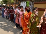 People in queues to cast their vote showing voter ID cards during the fifth phase of West Bengal Assembly Election 2021 in Salt Lake.(Samir Jana/HT Photo)