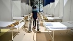 A worker carries oxygen cylinders seen inside a temporary isolation ward for Covid-19 patients amid the surge in coronavirus cases, at CWG Stadium in New Delhi on Monday. (ANI Photo) A worker carries oxygen cylinders seen inside a temporary isolation ward for Covid-19 patients amid the surge in coronavirus cases, at CWG Stadium in New Delhi on Monday. (ANI Photo)