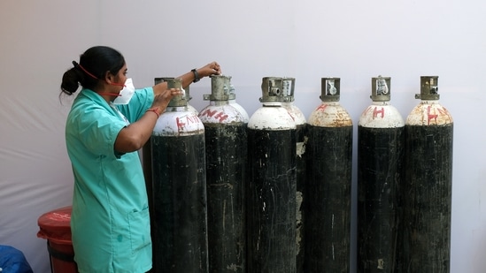 A health worker check oxygen cylinders at a makeshift Covid-19 quarantine facility set up in a banquet hall in New Delhi, India.(Bloomberg) A health worker check oxygen cylinders at a makeshift Covid-19 quarantine facility set up in a banquet hall in New Delhi, India.(Bloomberg)