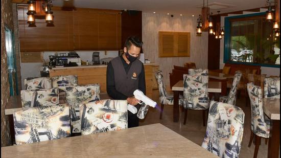 An employee carrying out sanitisation process at a restaurant in Ludhiana on Tuesday. (HarsimarPal Singh/HT) An employee carrying out sanitisation process at a restaurant in Ludhiana on Tuesday. (HarsimarPal Singh/HT)
