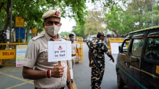 Policemen guarding a roadblock in New Delhi on April 20 as the national capital enters a week-long curfew in light of rising Covid-19 cases. The decision to impose a curfew came on April 19, with Delhi government citing a relentless surge in Covid-19 infections that has risen by close to 600% in the last two weeks and has now inundated hospitals and triggered a shortage in critical medical supplies.(Jewel Samad / AFP)