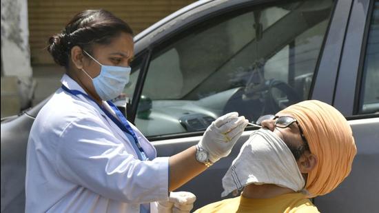 A health worker collecting a swab sample at the containment zone in Phase 1, Dugri, Ludhiana on Monday. (Gurpreet Singh/HT) A health worker collecting a swab sample at the containment zone in Phase 1, Dugri, Ludhiana on Monday. (Gurpreet Singh/HT)