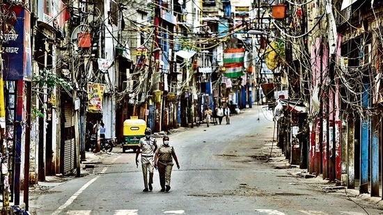 Civil defence personnel patrol a deserted street in Sadar Bazaar on Tuesday. (Sanjeev Verma/HT PHOTO)